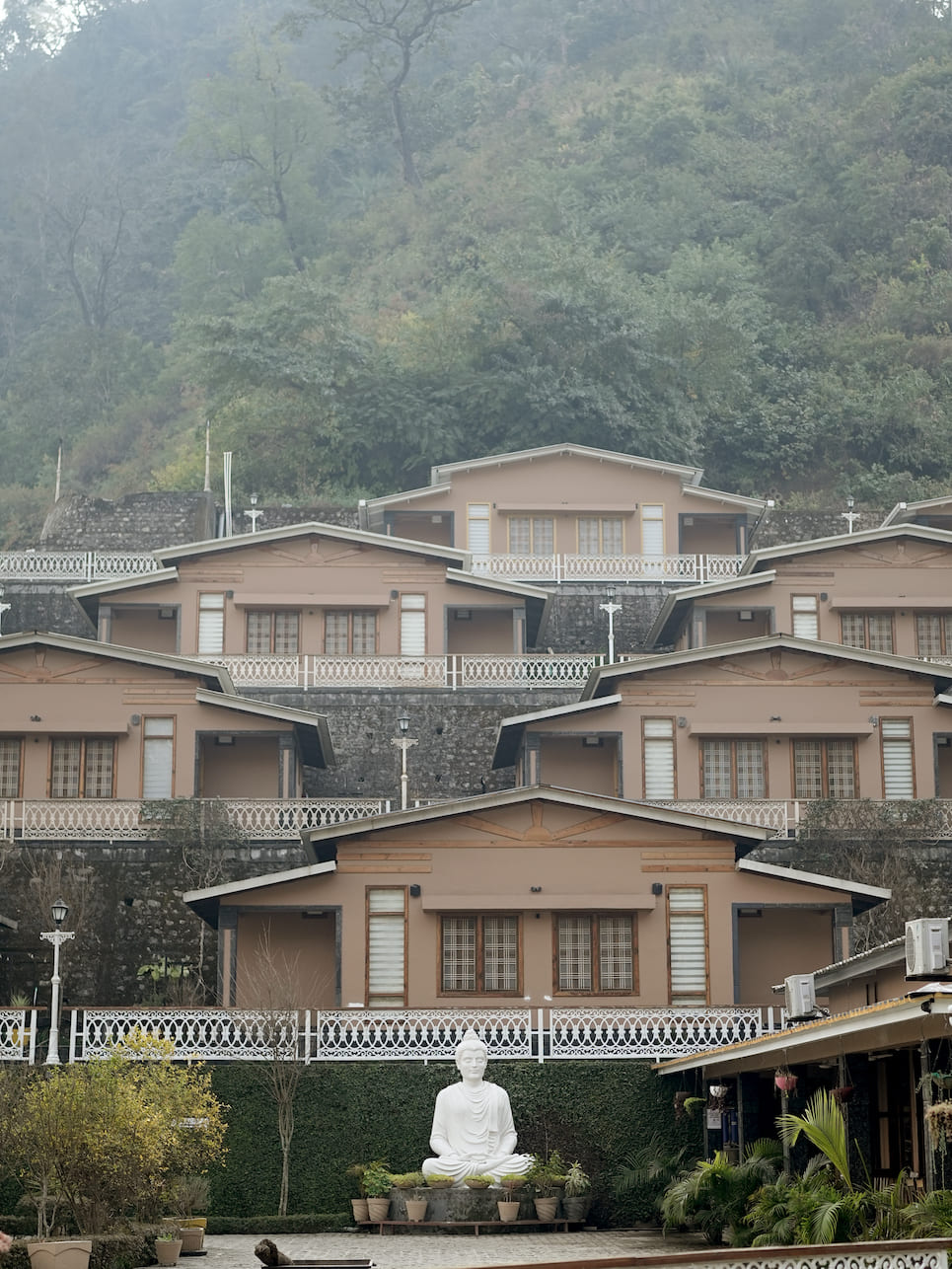 Rishikesh Yogpeeth terraced ashram campus with Buddha statue