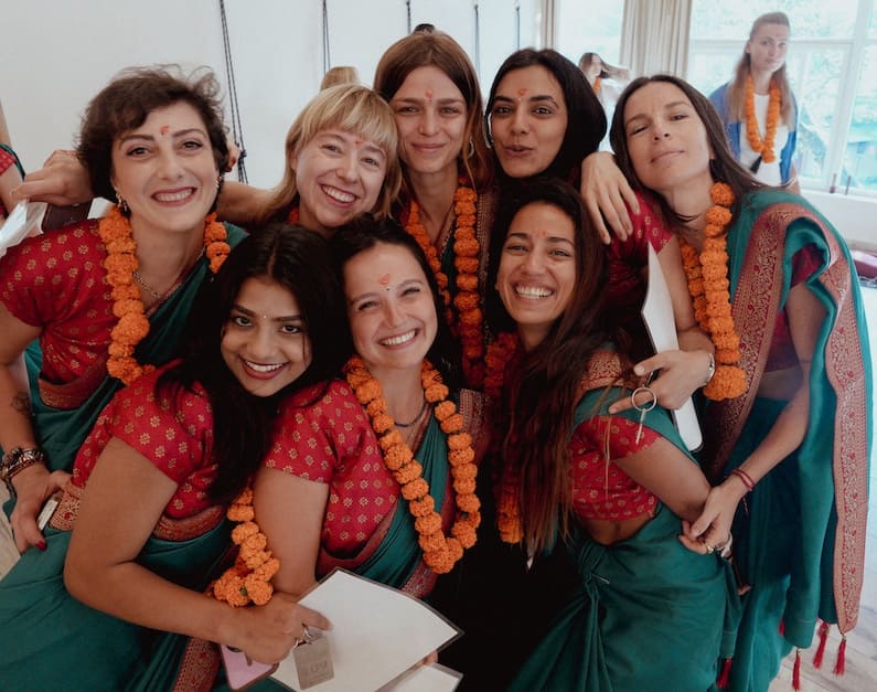 Yoga teacher training graduates celebrating in sarees and marigold garlands at Rishikesh Yogpeeth, Rishikesh India
