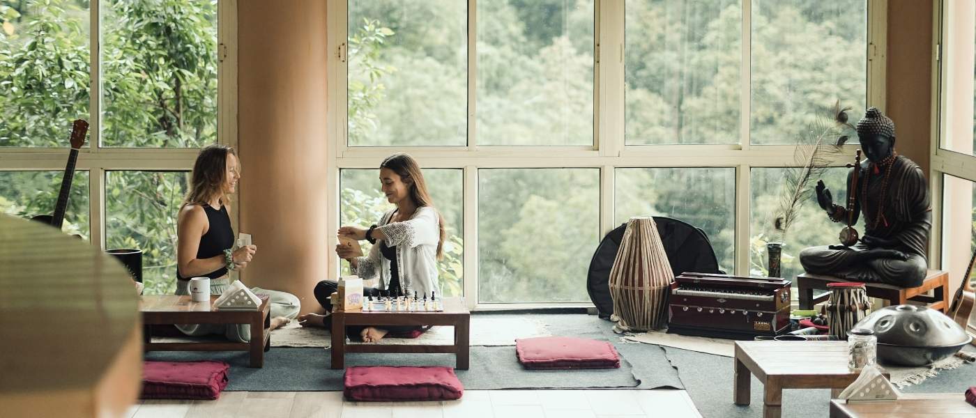 International yoga students relaxing in the ashram common room during yoga teacher training at Rishikesh Yogpeeth India